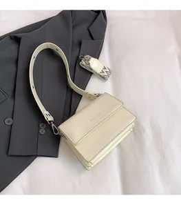 Close-up of cream patent leather crossbody bag with ethnic style woven shoulder strap
