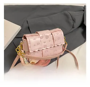 Détail d'un sac à bandoulière rose tressé avec des motifs mignons en relief