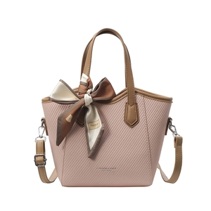 Sac seau texturé rose avec poignées marron et accessoire de foulard en soie décoratif