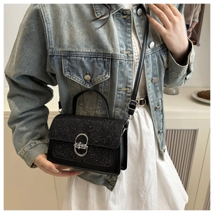 Nahaufnahme der schwarzen Pailletten-Handtasche mit silbernem Schloss an einem Model