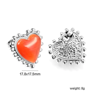 Détail de boucles d'oreilles cœur en œil de chat rouge avec bordure perlée argent