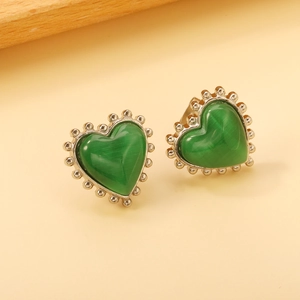 Vue macro de boucles d'oreilles cœur en œil de chat avec bordure en perles d'argent