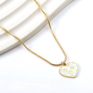 Close-up of heart clover pendant on gold snake chain with white shell inlay detail