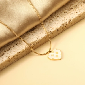 Detail of a 18K gold plated heart pendant necklace with clover shell inlay and snake chain