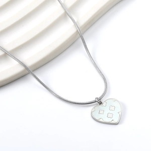 Detailed view of silver heart pendant with clover patterns on a sleek snake chain necklace