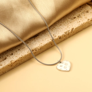 Detailed shot of clover shell heart pendant on a steel snake chain with 18K gold finish
