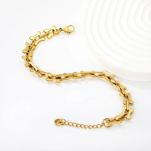 Macro detail of gold 18K plated stainless steel bone-shaped link chain with lobster clasp