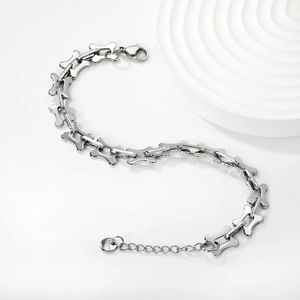 Detail of silver stainless steel bone-shaped link bracelet with lobster clasp and tag