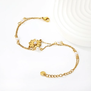 French style double-layer gold pearl bracelet featuring a sunburst pendant on white background