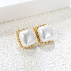 Detailed close-up of square pearl earrings with gold-toned twisted metal frame