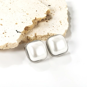 Detailed view of square faux pearl earrings with vintage silver twisted metal border