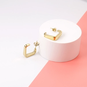 Boucles d'oreilles carrées évidées en acier inoxydable plaqué or 14K sur un socle