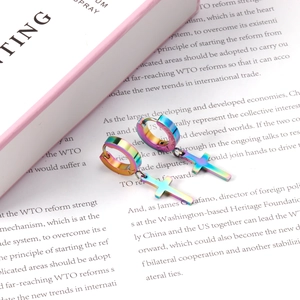 Classic rainbow stainless steel cross earrings with hoop dangles on an open book