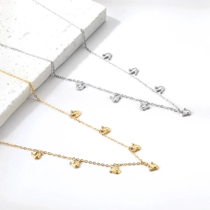 Collane con ciondolo a corona in oro 18 carats e argento su un supporto in marmo