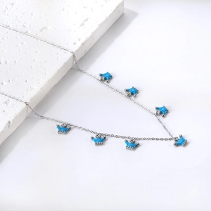 Dettaglio collana argentata con sei ciondoli a corona in smalto blu e piccoli zirconi