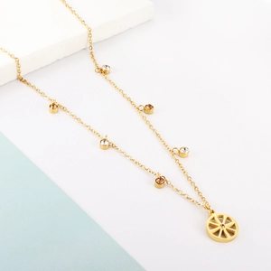 Detail of gold chain necklace featuring wheel pendant and multi-color crystal accents