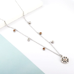 Macro detail of silver necklace featuring round brown gems and hollow wheel pendant design