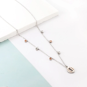 Close-up of silver chain necklace with amber gemstones and hollow oval shell pendant