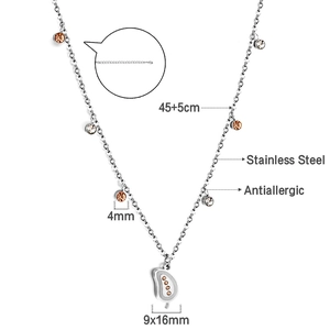 Detail of silver stainless steel necklace with orange zircons and leaf pendant