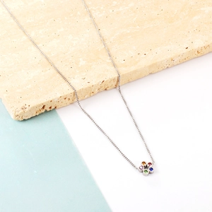 Détail du collier argenté avec pendentif fleur serti de pierres précieuses