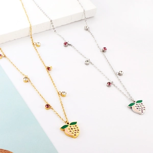 Detail of peach fruit pendant necklace with pink zircons and green enamel leaves