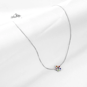 Collier à pendentif fleur avec pierres colorées sur fond de soie blanche minimaliste