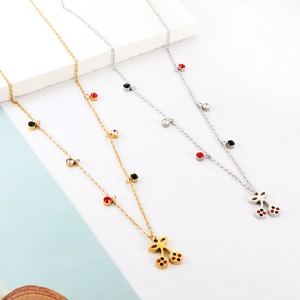 Detail of gold and silver cherry necklaces with red and green crystal accents