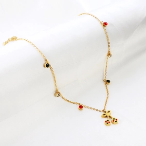 Close-up of golden station necklace featuring a colorful crystal-set cherry pendant