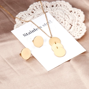 Parure bijoux dorée en acier inoxydable avec pendentifs ronds sur carte blanche