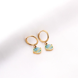 Détail de boucles d'oreilles dorées en acier avec pendentif planète bleu et vert émaillé
