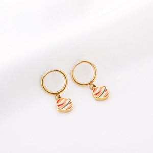 Gros plan de boucles d'oreilles planète dorées avec rayures colorées sur texture de soie