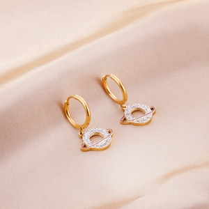 Boucles d'oreilles Saturne dorées avec émail violet et zircons sur fond de soie