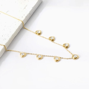 Elegante collana in acciaio inossidabile dorato con sette ciondoli a cuore e cristalli