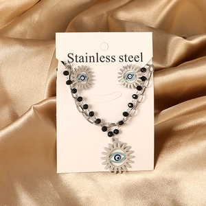 Dettaglio di parure collana e orecchini sole malocchio con perline nere in acciaio inossidabile