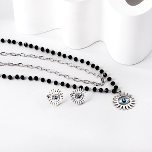 Dettaglio set gioielli malocchio con catena di perle nere e ciondolo sole in conchiglia