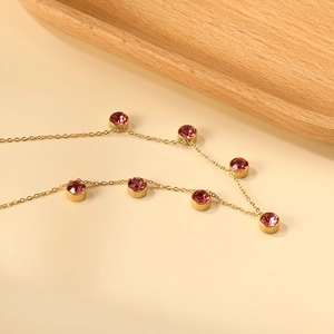 Dettaglio macro di una collana placcata oro 18K con sette cristalli rotondi rosa incastonati