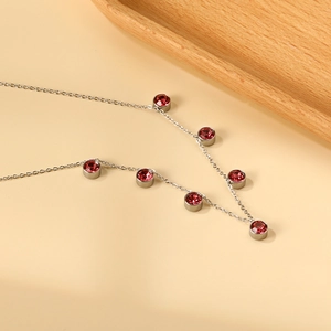 Dettaglio della collana in argento con sette cristalli rossi tondi incastonati a cornice