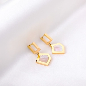 Golden geometric earrings with white mother-of-pearl shell pendants on silk background