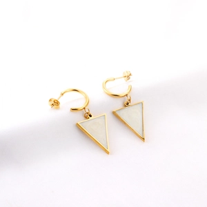 Golden triangle drop earrings with white marble inlay on a minimalist textured fabric