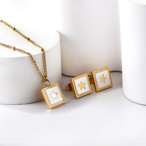 Detail of square gold satellite chain necklace and earrings set with white shell stars
