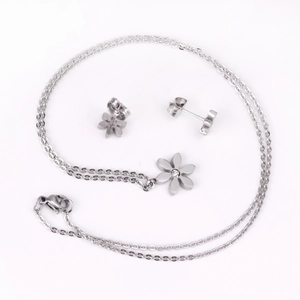 Détail d'un ensemble de bijoux fleurs argentées avec boucles d'oreilles et collier