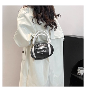 Detail of creative football-shaped PU leather handbag with metal chain and letter print