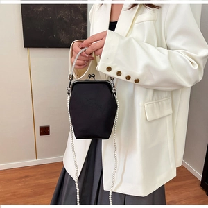Détail du sac rétro noir avec bandoulière en perles et poignée en chaîne métallique