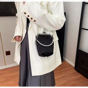 Détail de pochette en satin noir avec poignée lune en strass et bandoulière en perles