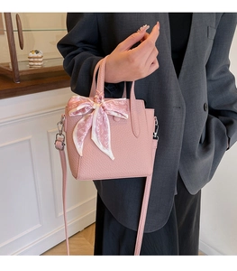 Vue détaillée d'un sac à main rose en cuir grainé avec foulard en soie à motif cœurs