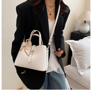 Détail du sac seau blanc avec texture lychee et foulard en soie à motif cœur