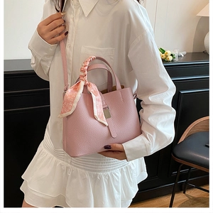 Vue détaillée du sac seau en cuir grainé rose avec foulard décoratif sur la poignée