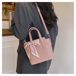 Sac seau rose texture litchi avec foulard à motifs porté en bandoulière sur mannequin