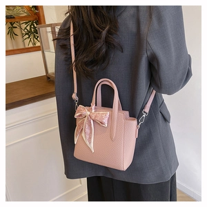 Sac seau rose en cuir grainé avec foulard à motifs cœurs sur la poignée haute