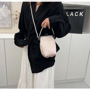 Détail du sac brodé de style chinois avec bandoulière perle et poignée en cristal